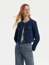 A lady wears a short denim jacket.
